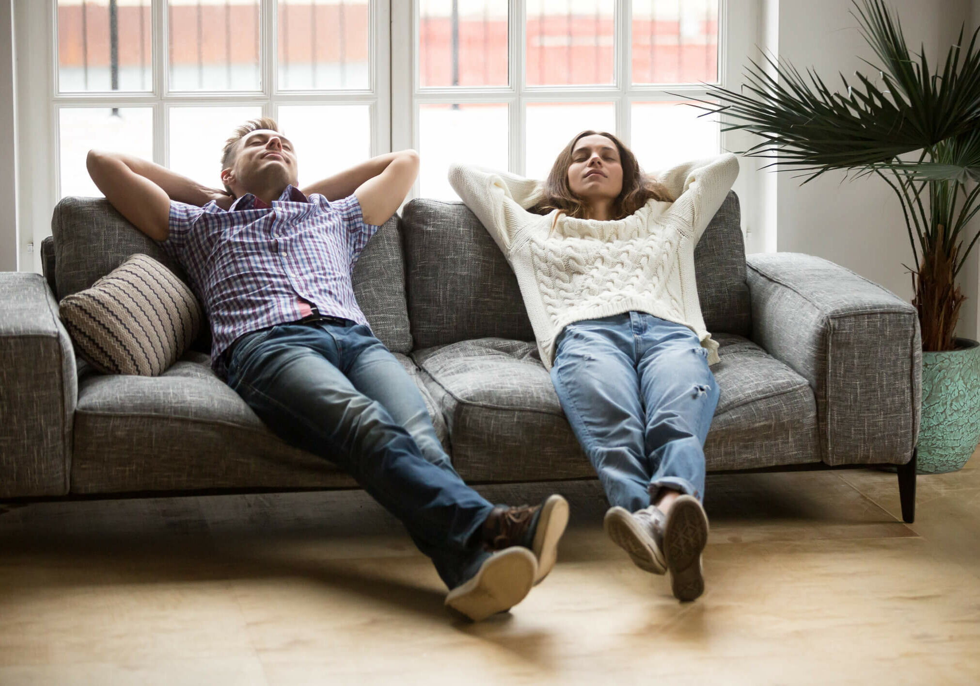 HVAC Replacement and Installation services - couple relaxing on the couch in their warm home