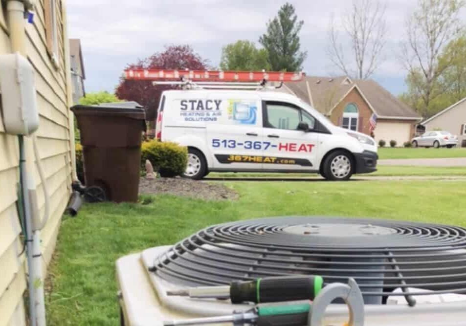 Quality HVAC Contractor in Harrison Ohio - Air conditioning unit with a Stacy Heating and Air Solutions van